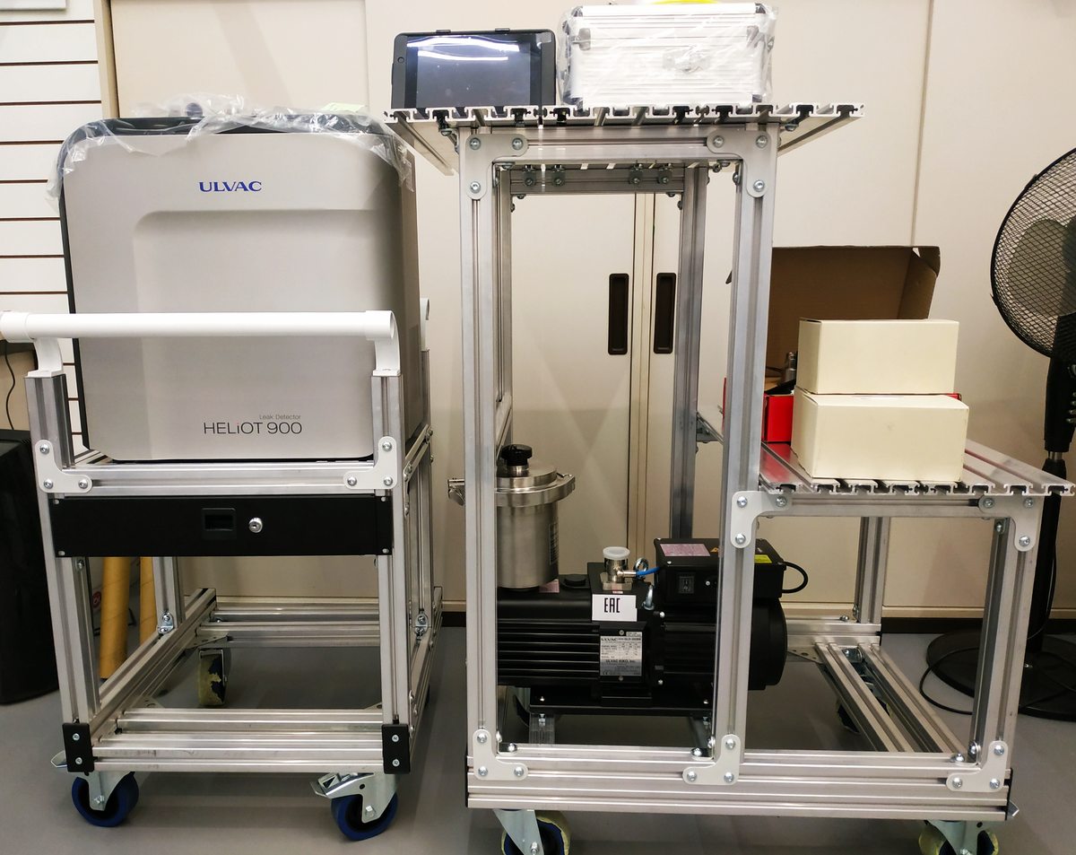 ULVAC HELIOT 900 на мобильной раме рядом с форвакуумным насосом и вспомогательной обвязкой.