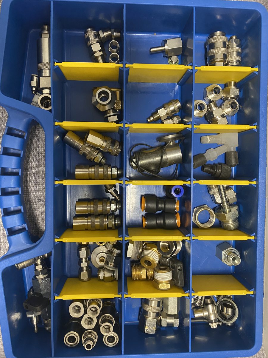 Присоединительные детали и зажимы разложены по ячейкам для сборки вакуумной обвязки.